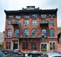 a red brick building with cars parked in front of it