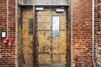 a doorway with a brick wall and a metal door